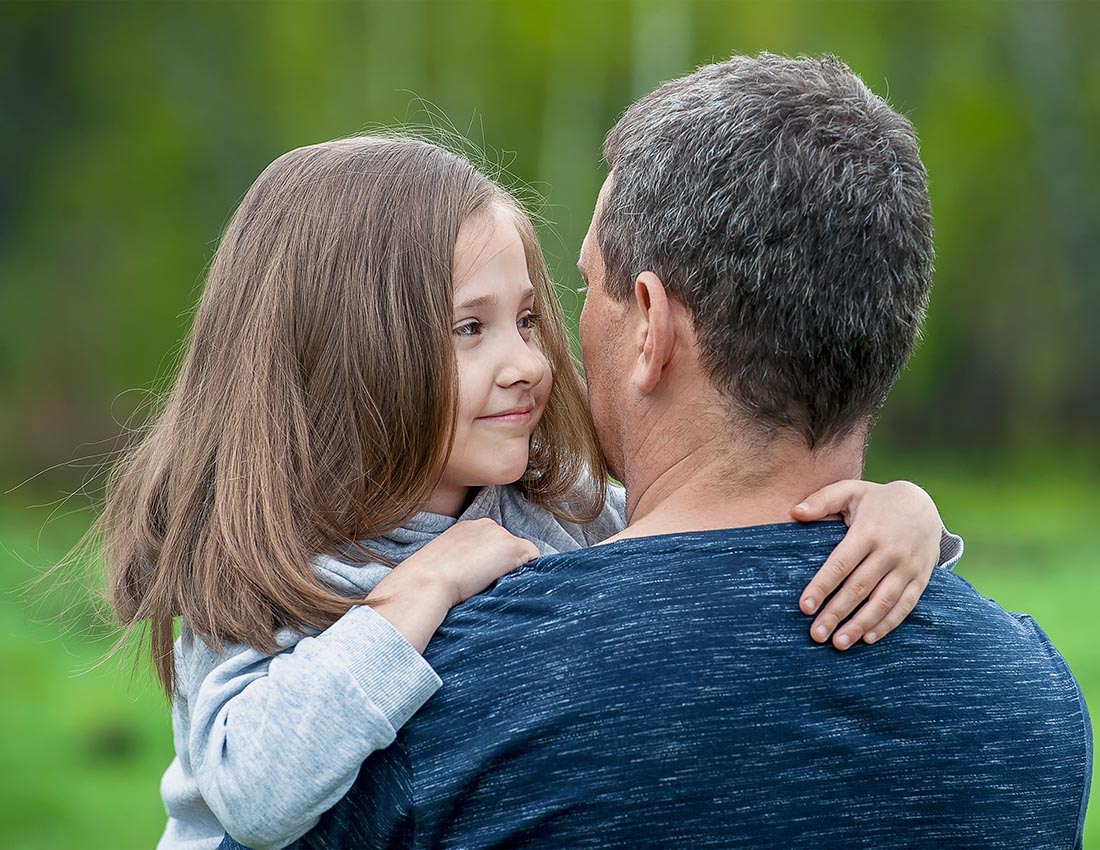 Girl hugging her father. Happy loving family. Dad and his daughter playing. Cute baby and daddy. Concept of Father day. Family holiday and togetherness. Green background