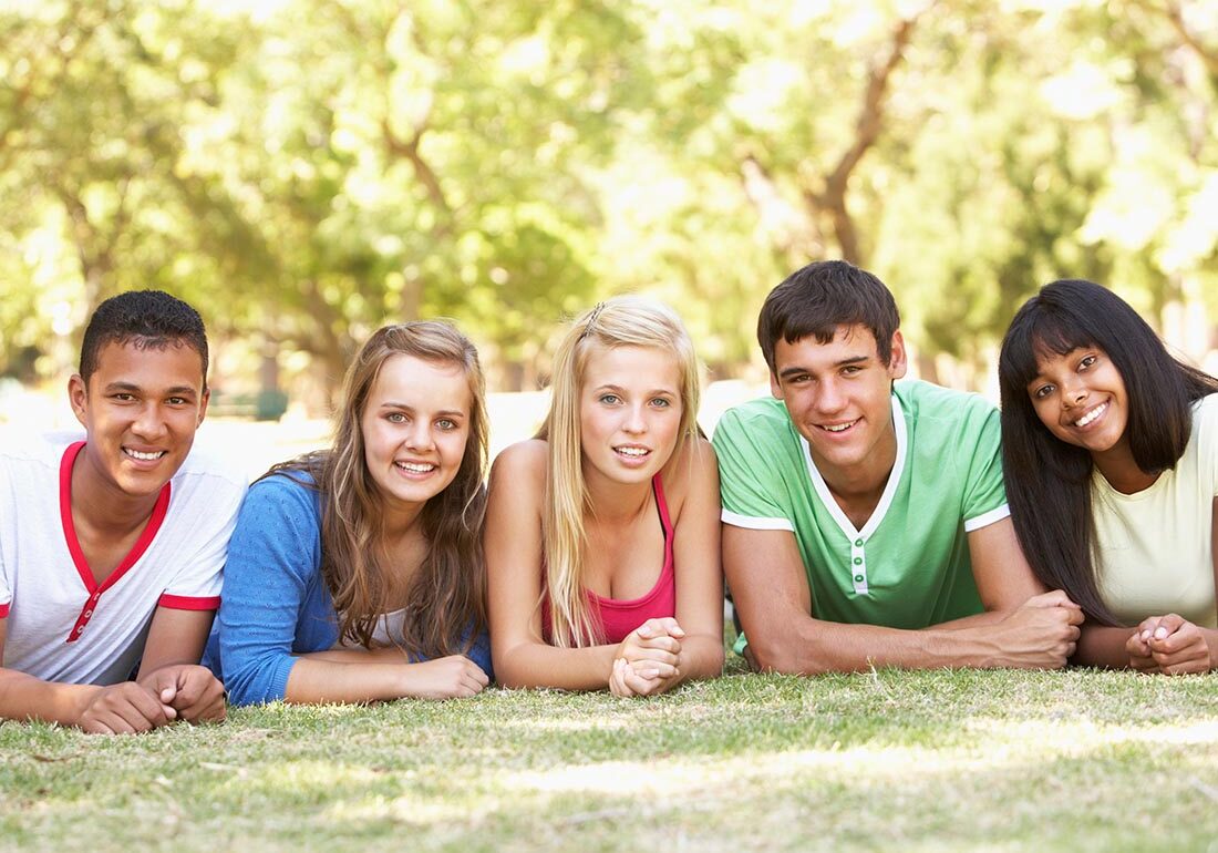 Group Of Teenage Friends Relaxing In Park Together